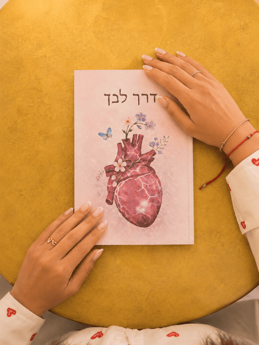 אישה קוראת בספר דרך לבך ליד חלון באור טבעי